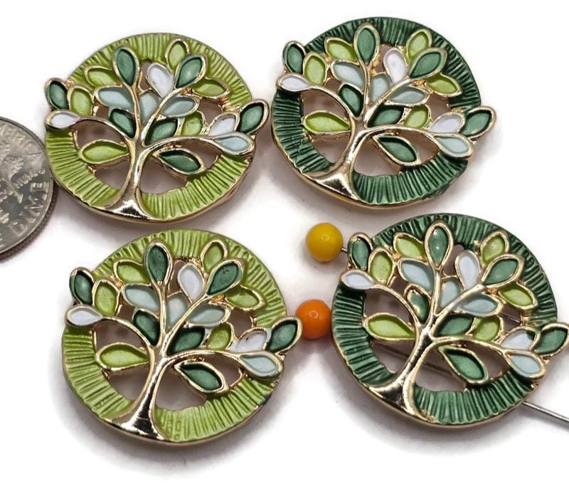Beautiful Green Tree of Life 2 Hole Slider Beads featuring vibrant lime green, deep forest green, soft mint, and white enamel leaves accented by bright reflective gold branches. These round jewelry focal beads showcase contrasting bright lime and dark green textured circular backgrounds with intricate openwork tree designs. Perfect jewelry making supplies for handmade bracelets, necklace designs, multi-strand jewelry, and bead weaving projects inspired by nature and colorful botanical themes.