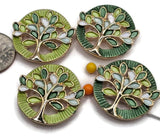Beautiful Green Tree of Life 2 Hole Slider Beads featuring vibrant lime green, deep forest green, soft mint, and white enamel leaves accented by bright reflective gold branches. These round jewelry focal beads showcase contrasting bright lime and dark green textured circular backgrounds with intricate openwork tree designs. Perfect jewelry making supplies for handmade bracelets, necklace designs, multi-strand jewelry, and bead weaving projects inspired by nature and colorful botanical themes.