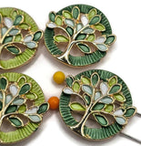 Stunning round Tree of Life Slider Beads featuring bright reflective gold branches surrounded by beautiful emerald green, lime, mint, and white enamel leaves. These decorative jewelry components include coordinating dark green and bright lime textured circular backgrounds with intricate openwork detailing. Wonderful focal beads for handmade bracelets, beaded necklaces, multi-strand jewelry, and creative bead weaving. Versatile jewelry making supplies for designers