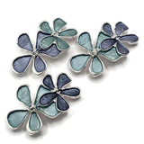 Beautiful Blue Flower 2 Hole Slider Beads featuring three overlapping enamel flowers in dusty blue, deep slate blue, and soft aqua shades. Each floral jewelry focal bead features bright reflective silver outlines, delicate raised silver centers, and decorative five-petal blossoms. Perfect jewelry making supplies for handmade bracelets, necklace designs, multi-strand jewelry, and creative bead weaving projects. floral jewelry components for creating colorful nature-inspired handmade jewelry.