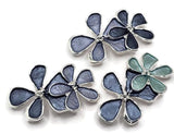 Stunning floral 2 Hole Slider Beads featuring deep blue enamel flowers with a contrasting light aqua blossom. Each decorative jewelry component showcases three overlapping flowers with rich slate blue petals, bright reflective silver borders, and delicate raised silver centers. These beautiful focal beads are perfect for handmade bracelets, beaded necklaces, multi-strand jewelry, and creative bead weaving.