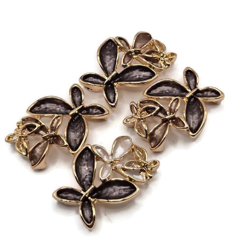 Beautiful charcoal gray and champagne floral 2 Hole Slider Beads featuring three overlapping flowers with textured smoky gray, soft taupe, and pearly ivory enamel petals. Each decorative jewelry focal bead showcases highly reflective bright gold outlines and delicate openwork gold flower accents. These elegant jewelry components are perfect for handmade bracelets, necklace designs, bead weaving, and multi-strand jewelry.