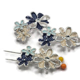 Beautiful silver floral focal beads featuring soft cream-colored blossoms accented by rich navy blue and delicate light blue enamel flowers. Each decorative jewelry component showcases dimensional petals, textured enamel surfaces, raised metallic centers, and polished silver openwork details. These 2 Hole Slider Beads are ideal for bracelet making, bead weaving, necklaces, and creative multi-strand jewelry.