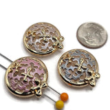 Package of three round floral 2 hole slider beads in a polished bright gold finish with assorted pastel enamel colors. Each decorative bead measures approximately 22 mm in diameter with 6 mm between the holes. The circular design features intricate filigree cutouts, softly textured enamel, and dimensional gold flower accents. Perfect for handmade bracelets, necklaces, decorative cuffs, bead weaving, and vintage-inspired jewelry.